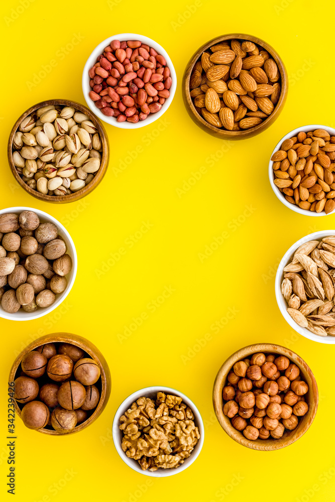 Set of macadamia, hazelnut, walnut, almond, pistachio, pecans nuts on yellow background top-down frame copy space mockup Set of macadamia, hazelnut, walnut, almond, pistachio, pecans nuts on yellow background top-down frame copy space mockup