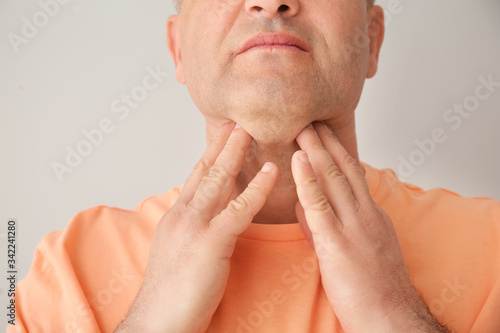 Mature man checking thyroid...