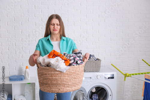 Canvas Print Troubled woman doing laundry in bathroom