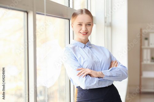 Portrait of young businesswoman near window in office