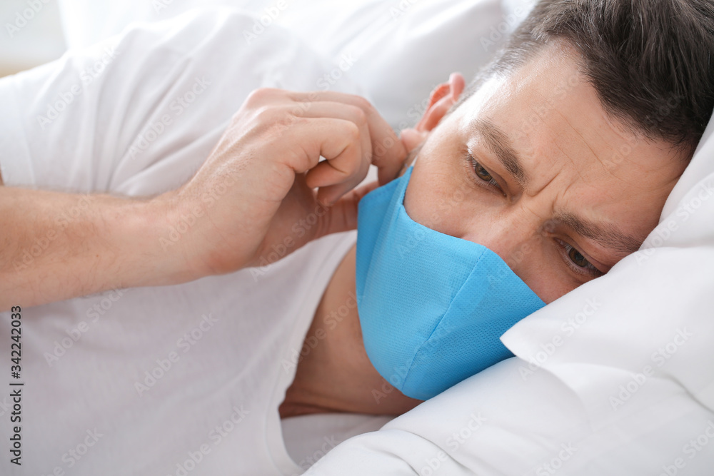 Ill man in protective medical mask at home Ill man in protective medical mask at home