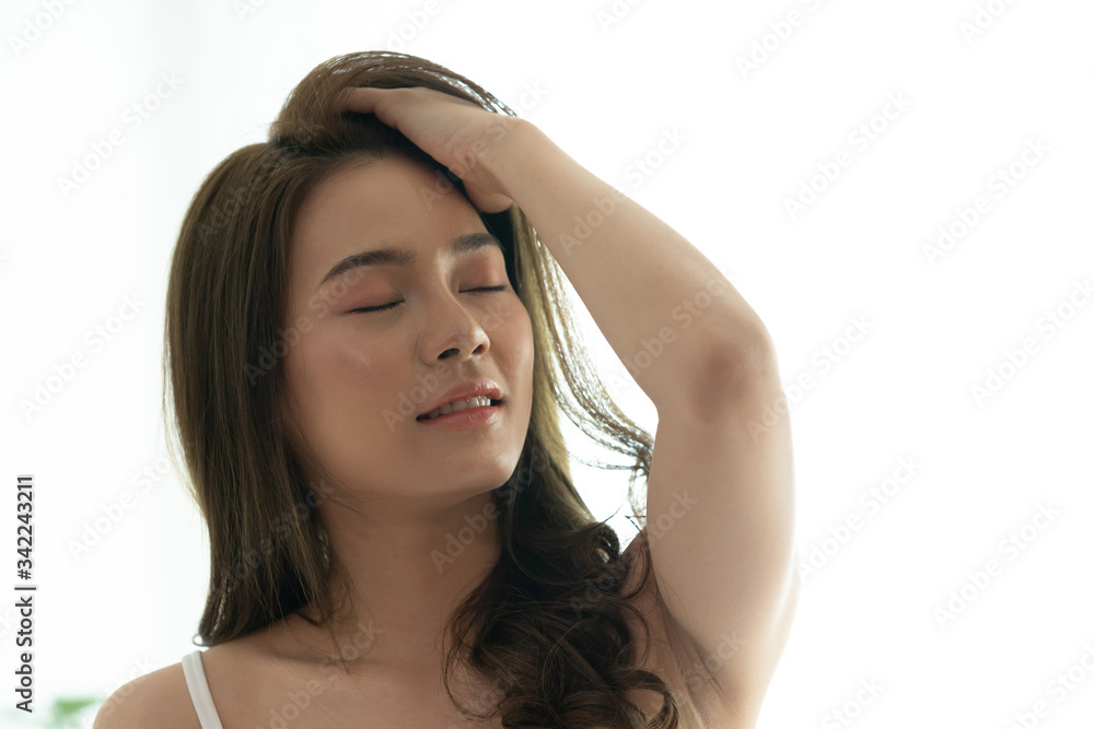 Asian woman cheerful and healthy and wearing white pajamas wake up on bed in bedroom in the morning.at home in holiday. Asian woman cheerful and healthy and wearing white pajamas wake up on bed in bedroom in the morning.at home in holiday.