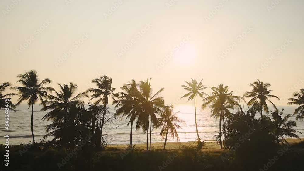 A car crossing in the beautiful sunset by the Varkala Beach in India, romantic drive - wide shot A car crossing in the beautiful sunset by the Varkala Beach in India, romantic drive - wide shot