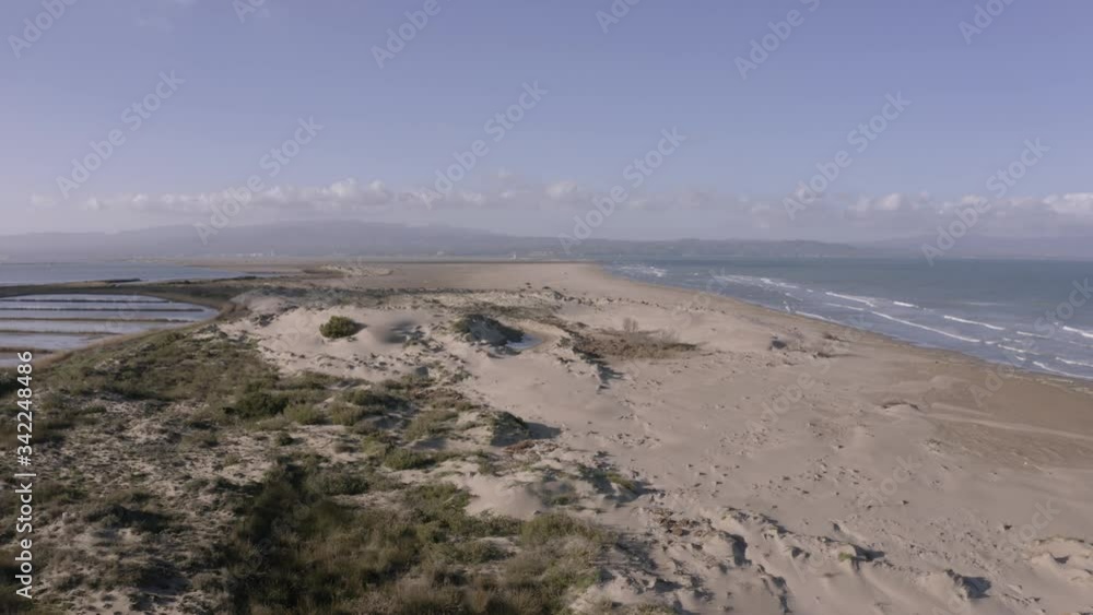 Stunning aerial view of sand dunes of Delta del Ebro, Spain. Popular holiday destination for bird watching, hiking and visiting lighthouse. Scenic drone view of beach and coast. Stunning aerial view of sand dunes of Delta del Ebro, Spain. Popular holiday destination for bird watching, hiking and visiting lighthouse. Scenic drone view of beach and coast.