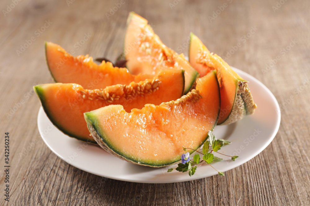 melon slices on plate on wood background melon slices on plate on wood background