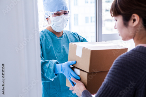 宅配員がウイルス感染対策をして配達している © Monet