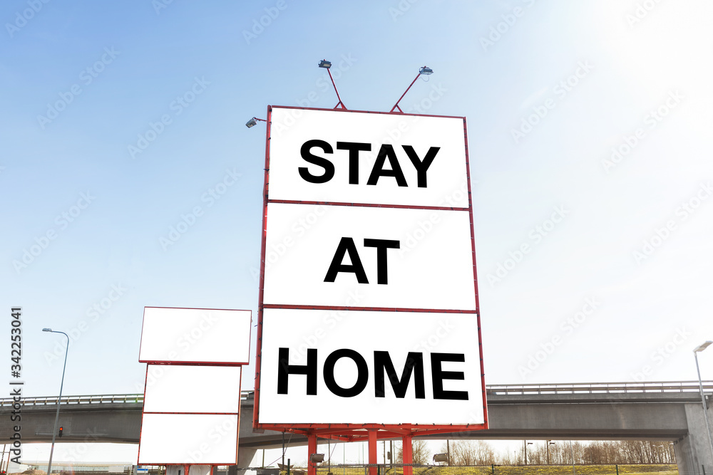 quarantine, caution and information concept - big white billboard with stay at home words in city