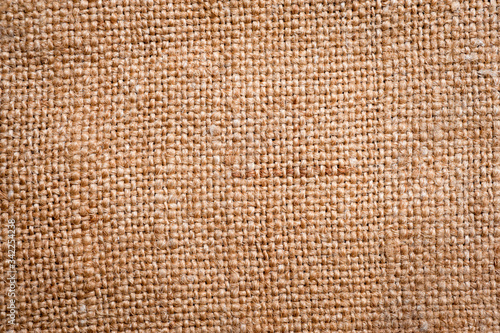 A canvas napkin lying on a wooden surface. Background for fall and natural objects.