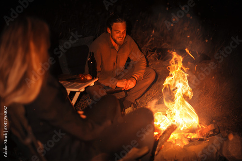 Two people around a campfire at night
