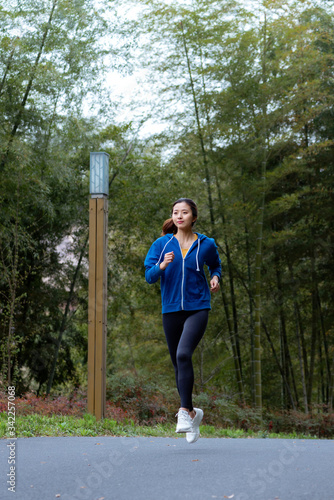A young Asian female running outdoors