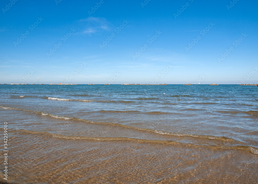 People are resting on a sunny day at the beach in Cesenatico, Italy