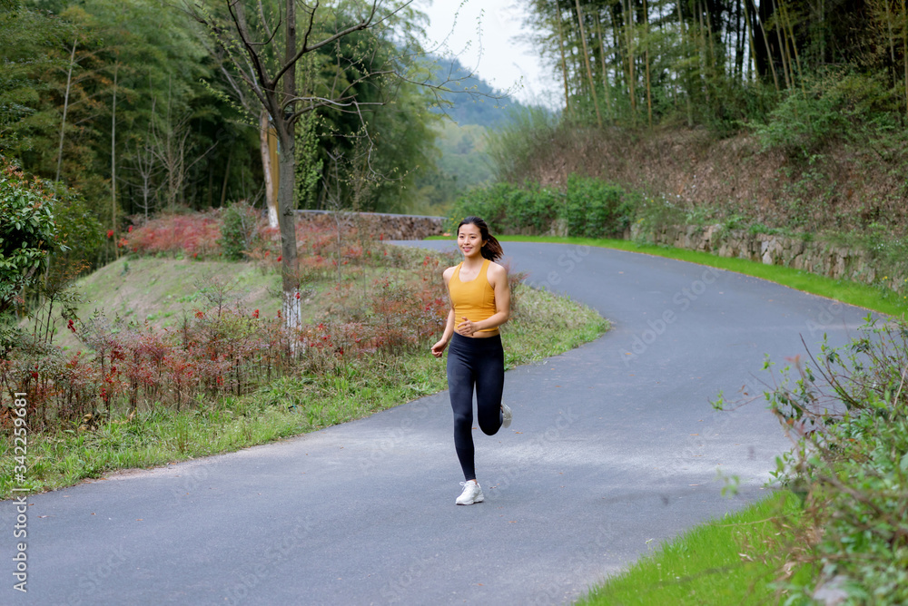 A young Asian female running outdoors A young Asian female running outdoors