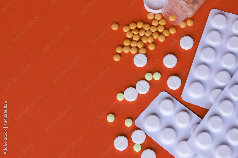 Assorted pharmaceutical medicine pills, tablets and capsules on orange background Assorted pharmaceutical medicine pills, tablets and capsules on orange background