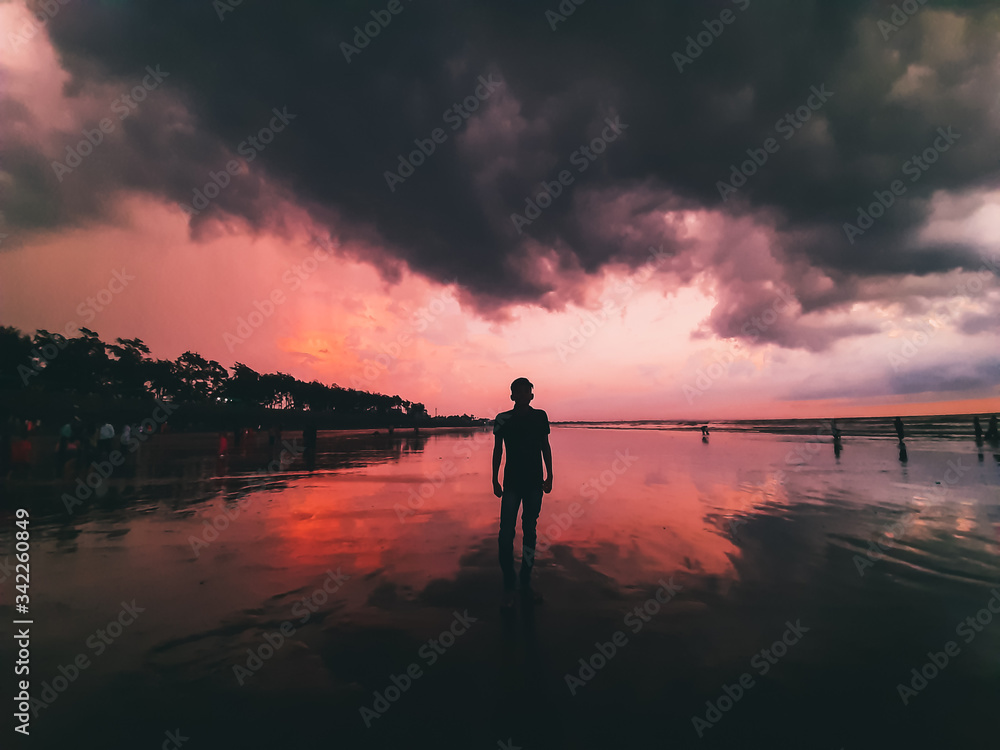 silhouette of a man walking on the beach