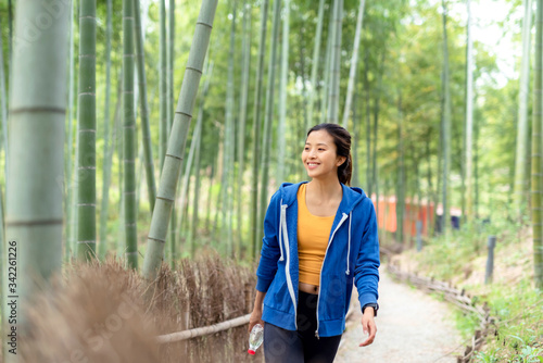 A young Asian woman walking in the bamboo forest