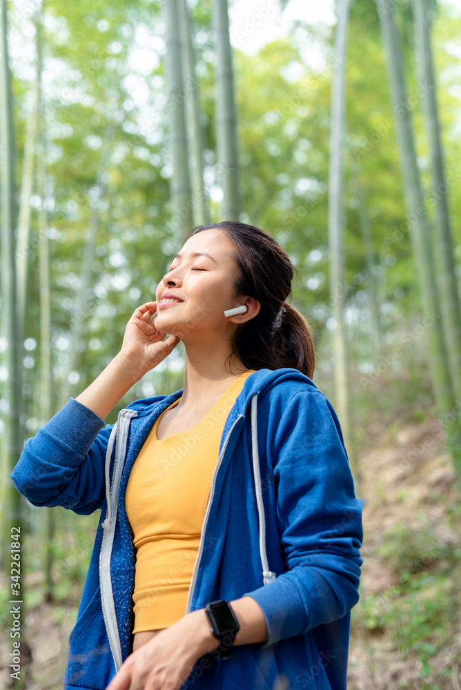A young Asian woman walking in the bamboo forest A young Asian woman walking in the bamboo forest