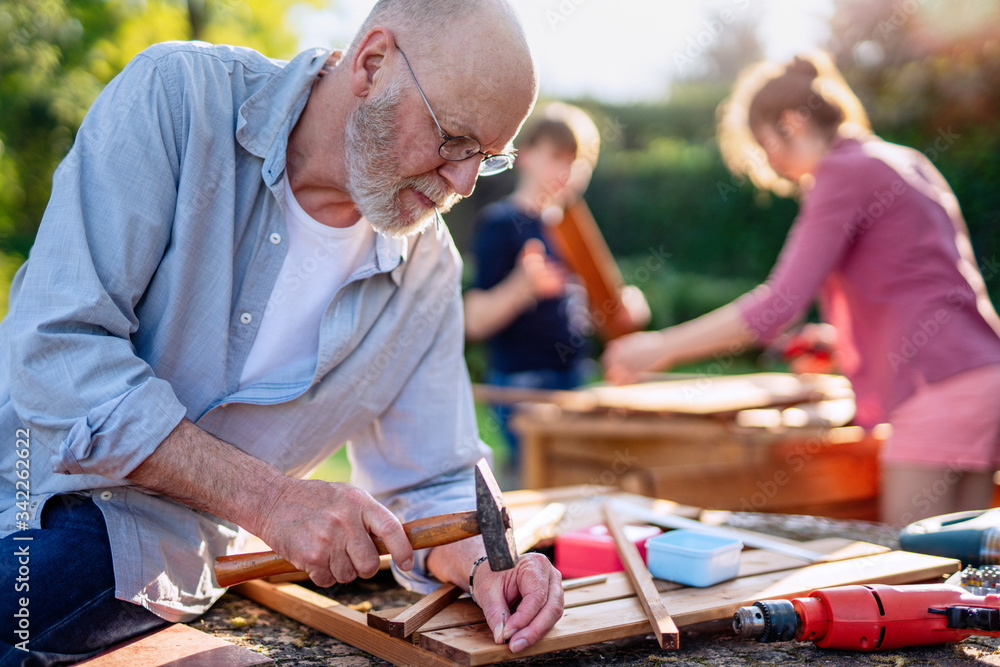 Φωτογραφία A man and his family are building wooden planters for their vegetable garden
