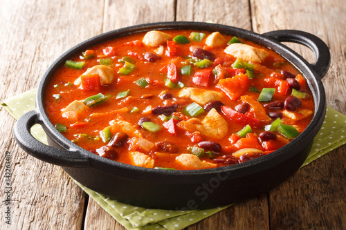 Homemade recipe for chicken stew with red beans in hot chili sauce close-up in a pan. horizontal