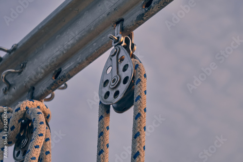 close-up sailboat equipment. Rope in snatch block at sunset. Yachting concept and sea background.