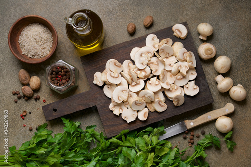 Sliced mushrooms on cutting board. Champignons, Herbs and spices on the table. Cooking Vegan, Healthy Food