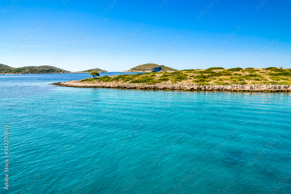 Beautiful lagoon with turquoise water of sea. Mediterranean scenery with blue sky, sea and island. Croatia, vacation travel concept.