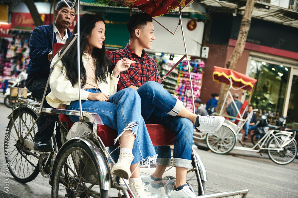 Obraz premium Wide shot of couple traveling by Vietnamese pedicab