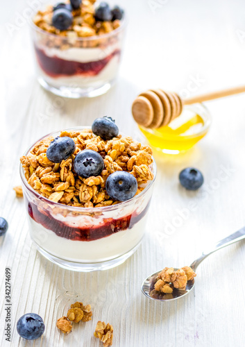 Fitness breakfast with muesli, honey and berries on white table