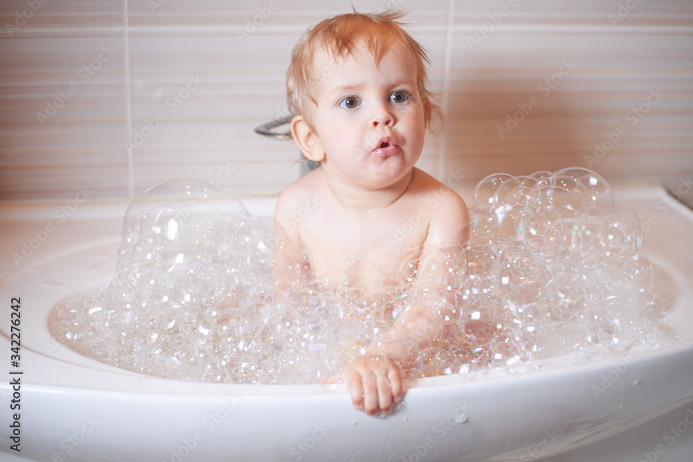 Funny child playing with water and foam in a bathroom. Funny child playing with water and foam in a bathroom.