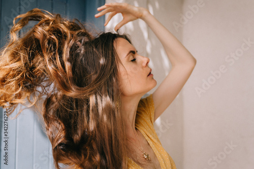 girl with long flying brown hair in summer in Mediterranean, on vacation