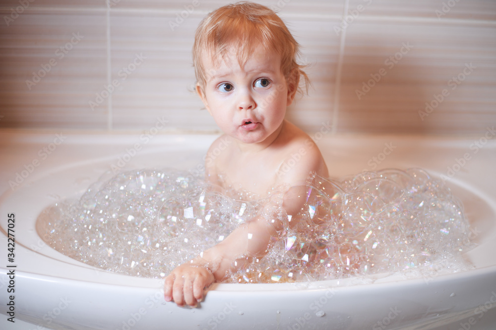Funny child playing with water and foam in a bathroom. Funny child playing with water and foam in a bathroom.