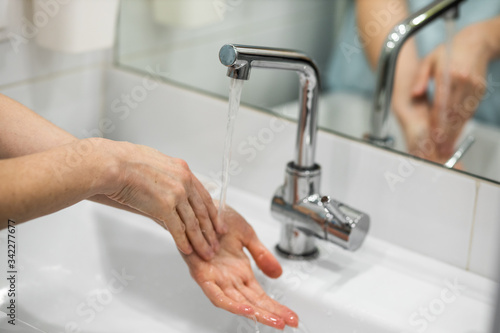 A woman washes her hands carefully with soap
