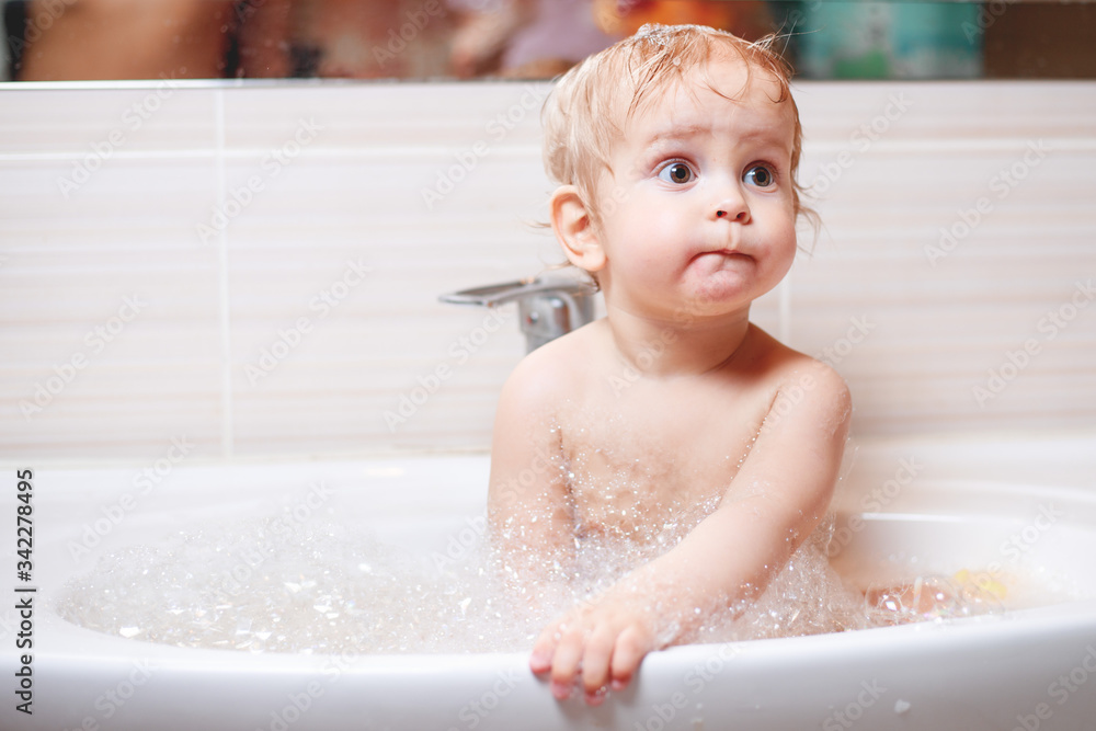 Funny child playing with water and foam in a bathroom. Funny child playing with water and foam in a bathroom.