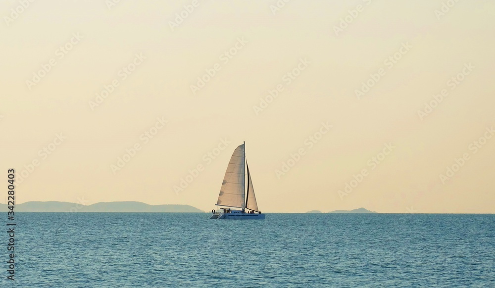 The sailboat is playing in the middle of the calm sea.