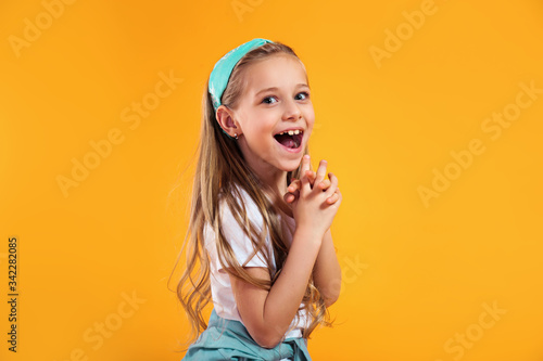 фотографія surprised little child girl in summer clothes on a colored yellow background