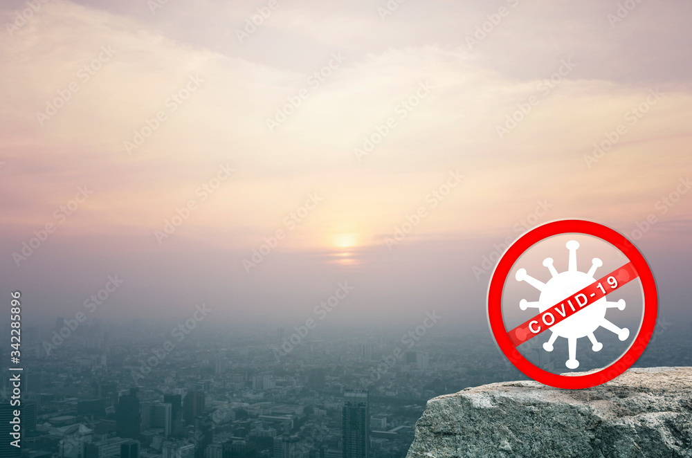 Stop COVID-19 outbreak icon on rock mountain over aerial view of cityscape at sunset, vintage style, Global epidemic alert, Concept of novel coronavirus outbreak