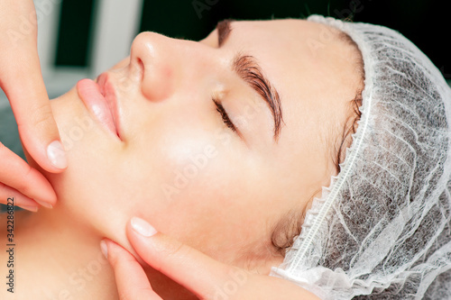 Photography Fingers of cosmetologist checking skin face of young woman before the liposuction procedure