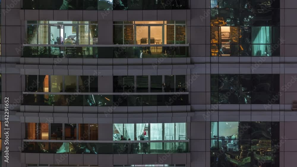 Night view of exterior apartment building timelapse. High rise skyscraper with blinking lights in windows with people moving inside Night view of exterior apartment building timelapse. High rise skyscraper with blinking lights in windows with people moving inside