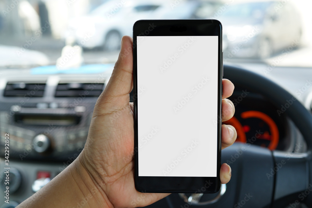 Cropped shot view of man hand holding a smartphone inside car with blank copy space screen for text message or information content Cropped shot view of man hand holding a smartphone inside car with blank copy space screen for text message or information content