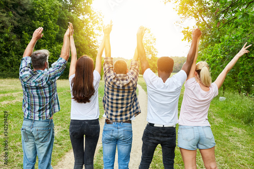 Jubelnde Freunde von hinten heben die Arme