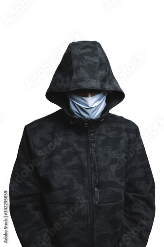 unrecognizable man with protective mask and hoodie looking down, concept of social distancing by the crisis of the coronavirus pandemic