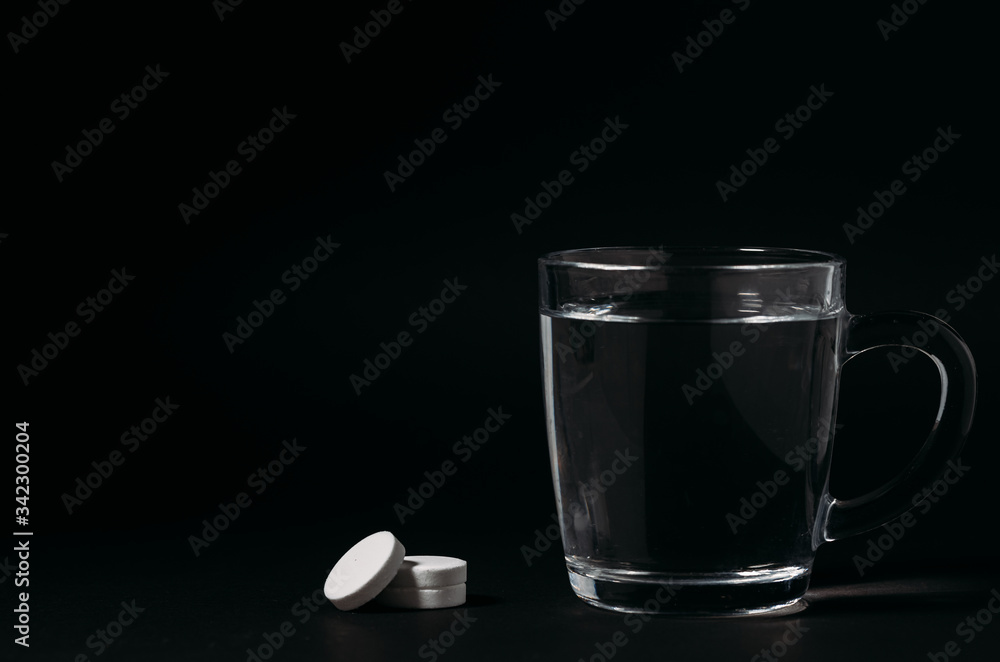 Glass with water on a black background. Cup of water. Glass with water on a black background. Cup of water.