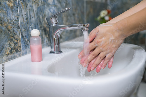 Fototapeta Naklejka Na Ścianę i Meble -  Woman use soap and washing hands under the water tap