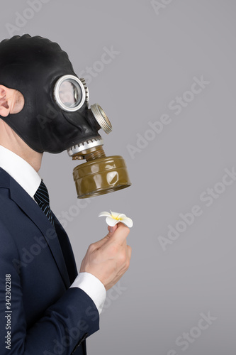 Close up portrait of man in a protective gas mask with flower photo