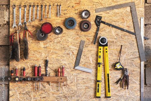 Various construction tools are hanging on the osb board