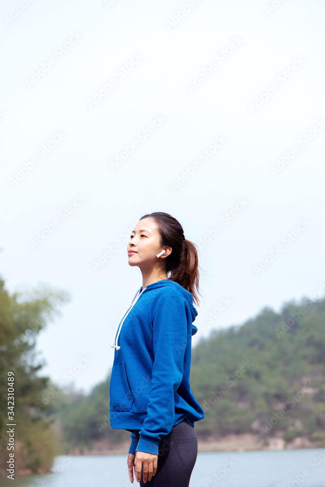 A young Asian woman practicing yoga in the outdoors