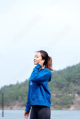 Fototapeta Naklejka Na Ścianę i Meble -  A young Asian woman practicing yoga in the outdoors
