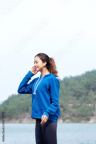 A young Asian woman practicing yoga in the outdoors