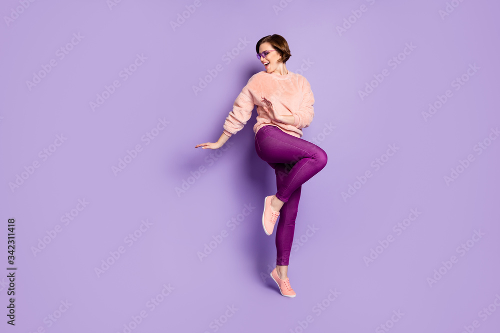 Full size photo of enthusiastic girl feel rejoice emotions dance on discotheque look copy space wear casual style clothing isolated over purple color background Full size photo of enthusiastic girl feel rejoice emotions dance on discotheque look copy space wear casual style clothing isolated over purple color background