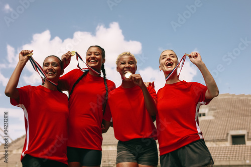 Female football team celebrating the win at stadium