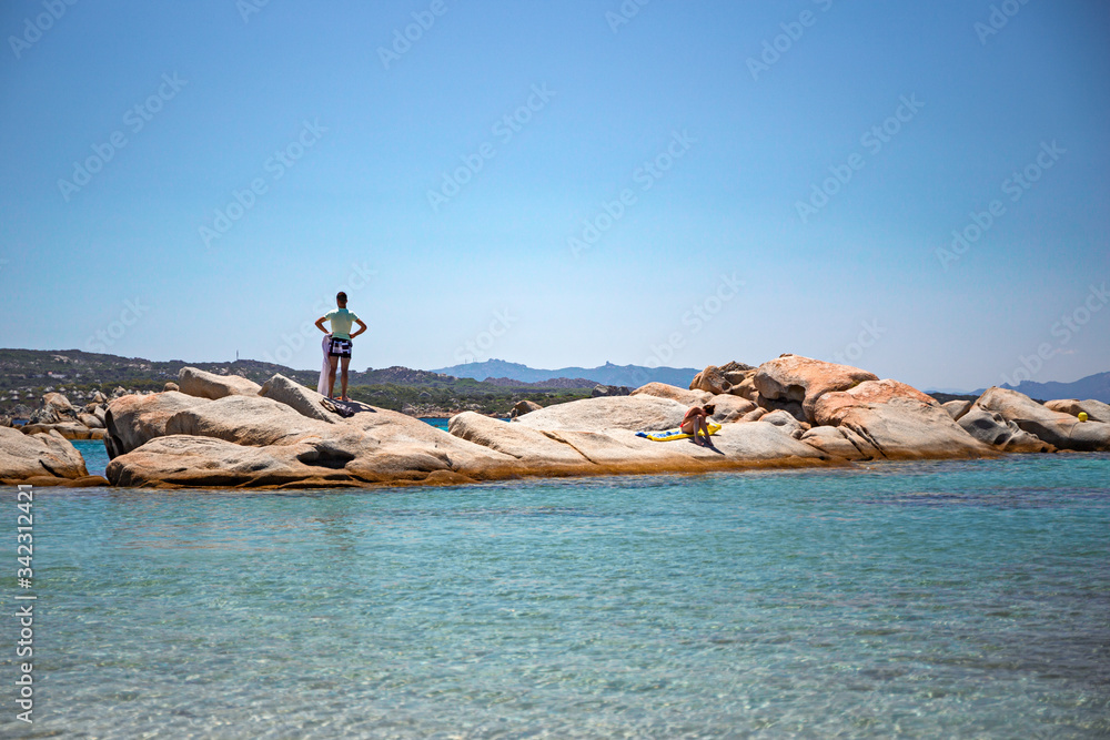 Some swimmers tan on the sunny beaches of the island of Maddalena in Sardinia, Italy.